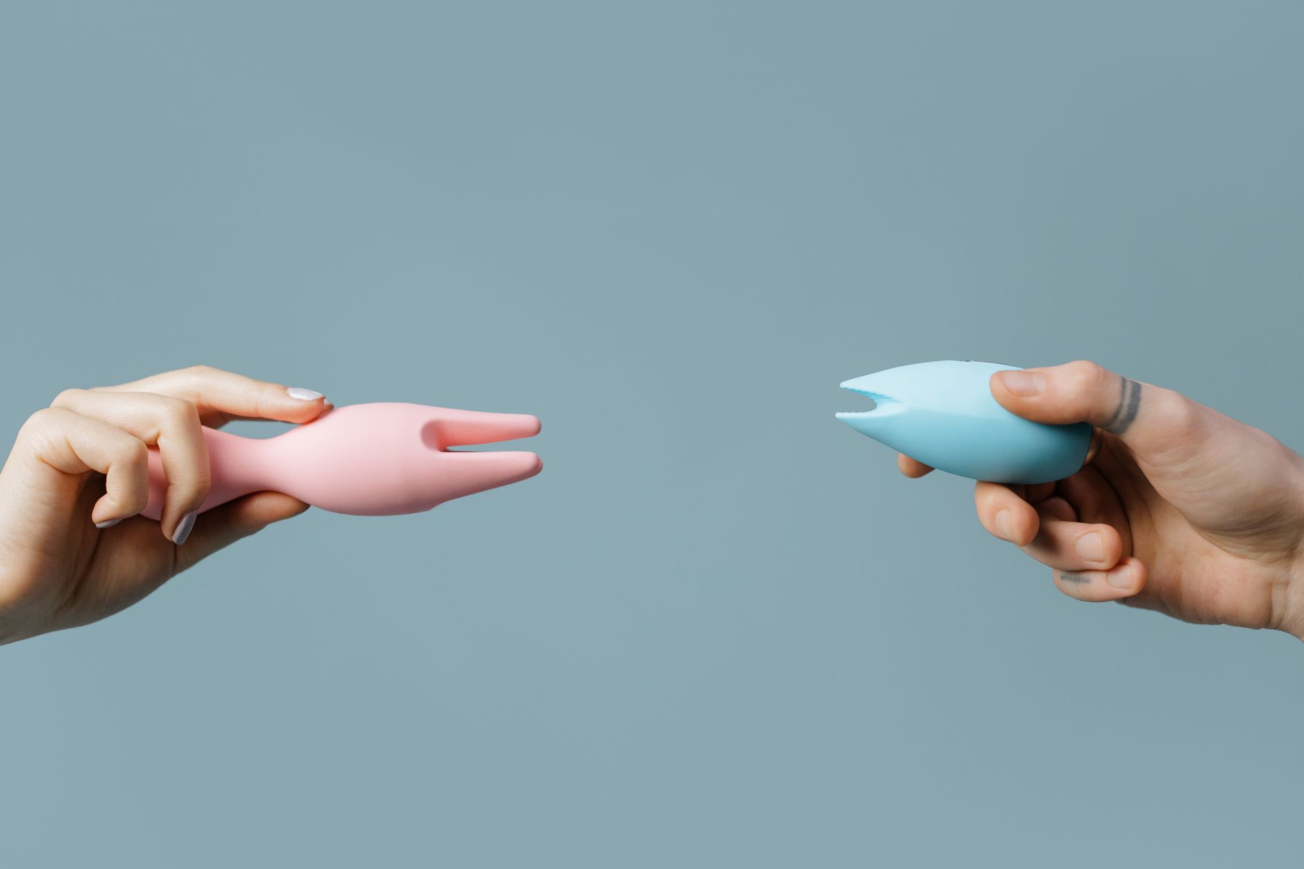 Two hands holding silicone vibrators