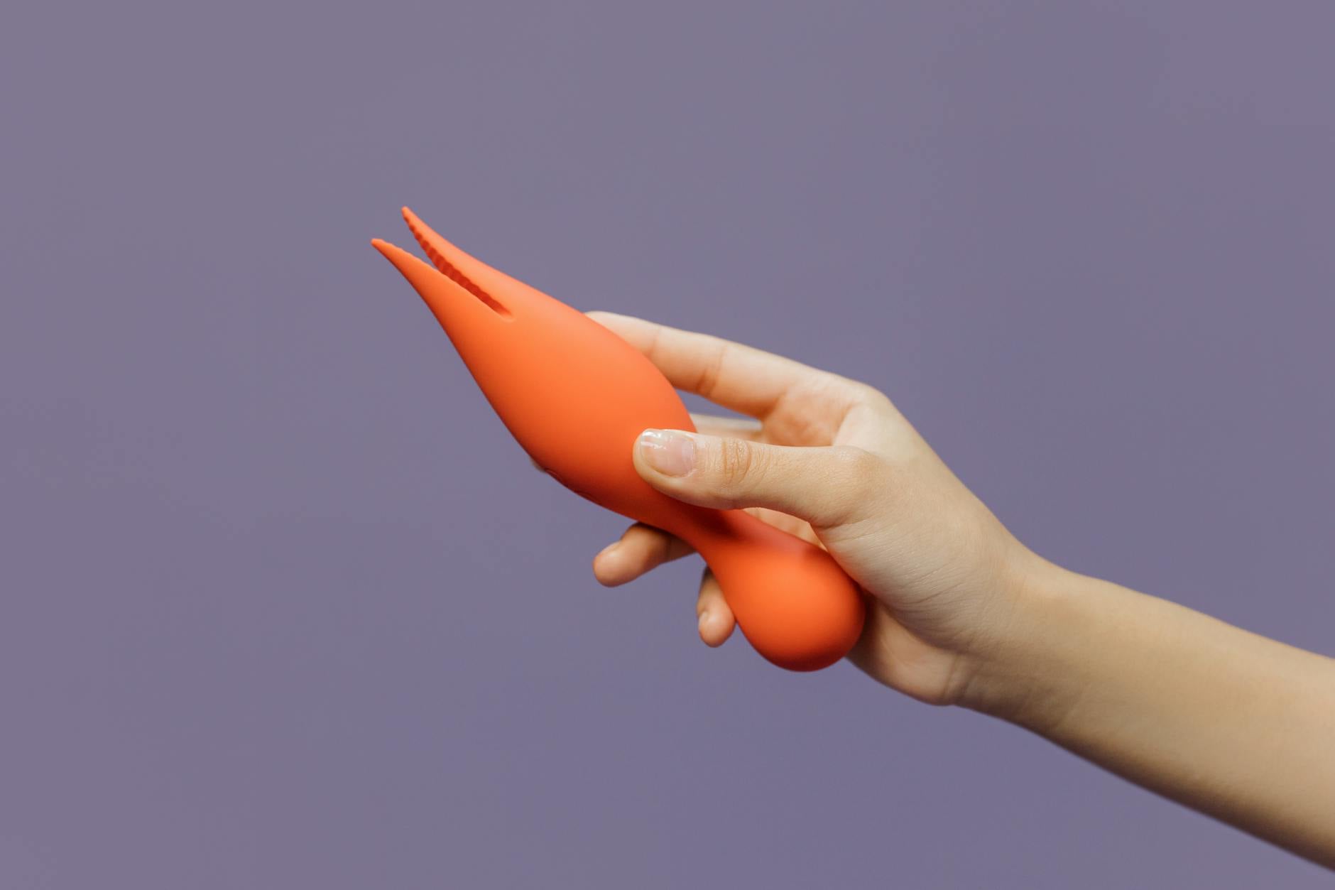 A close-up of hands holding a lemon vibrator, showcasing the serene focus and presence needed for pressure-free pleasure.